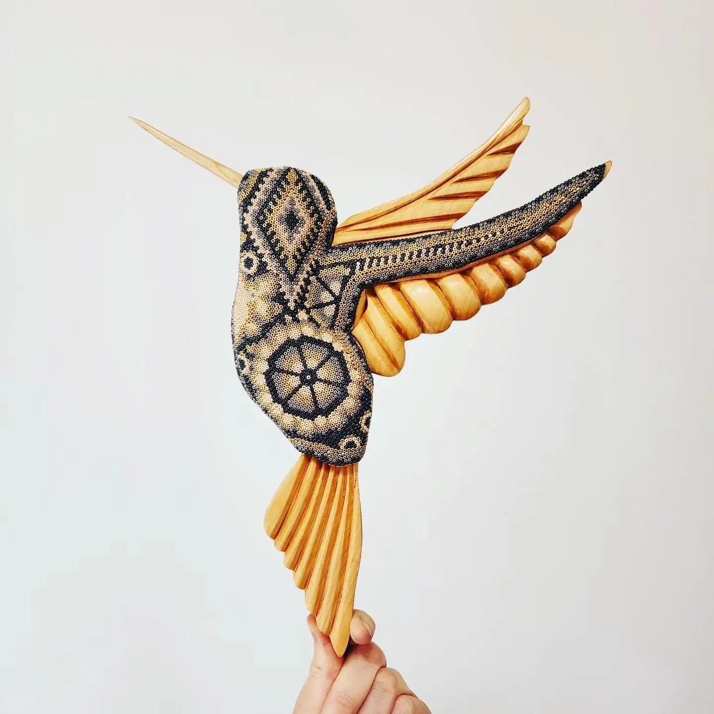 wooden hummingbird decorated with beads in the style of huichol art, mexican crafts