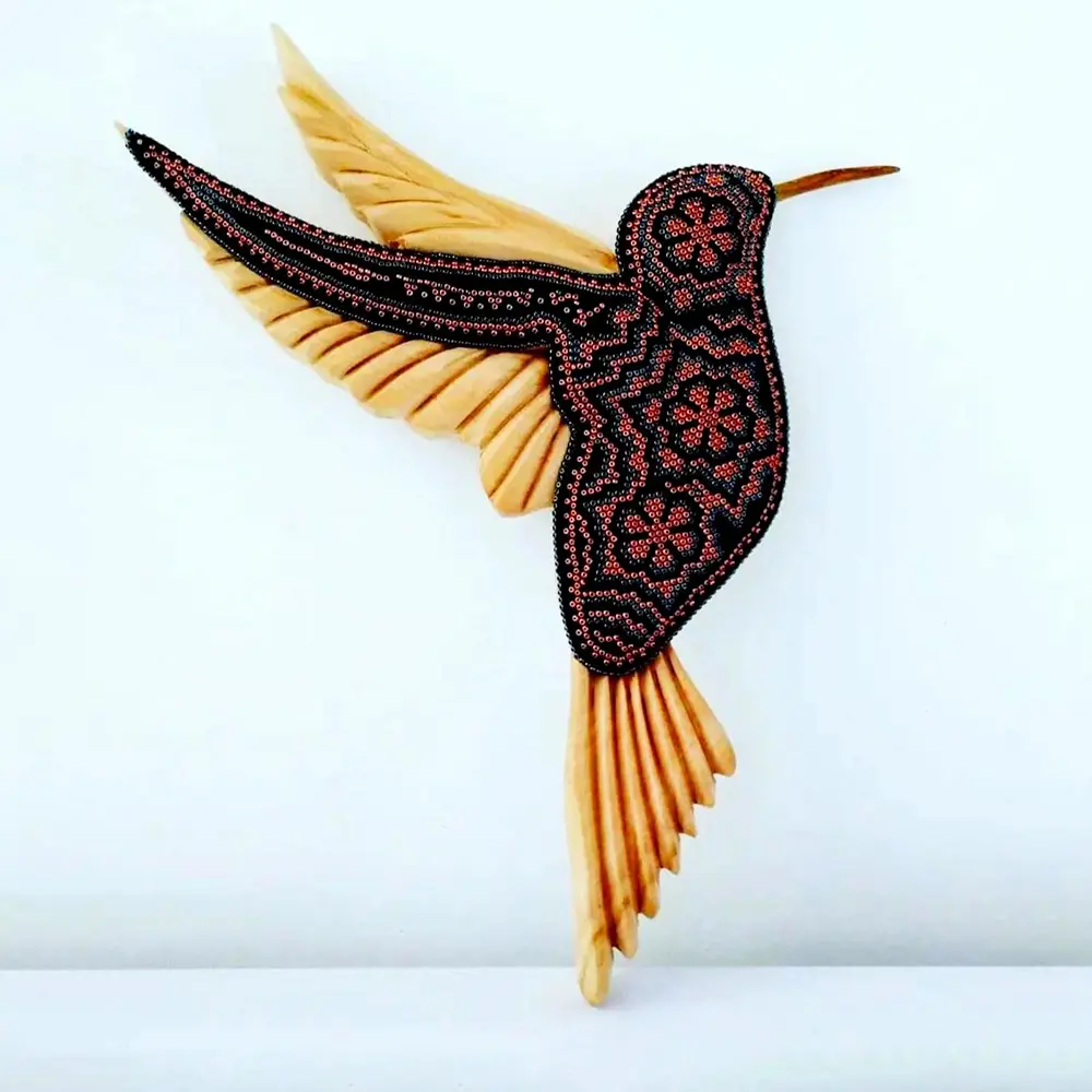 wooden hummingbird decorated with beads in the style of huichol art, mexican crafts