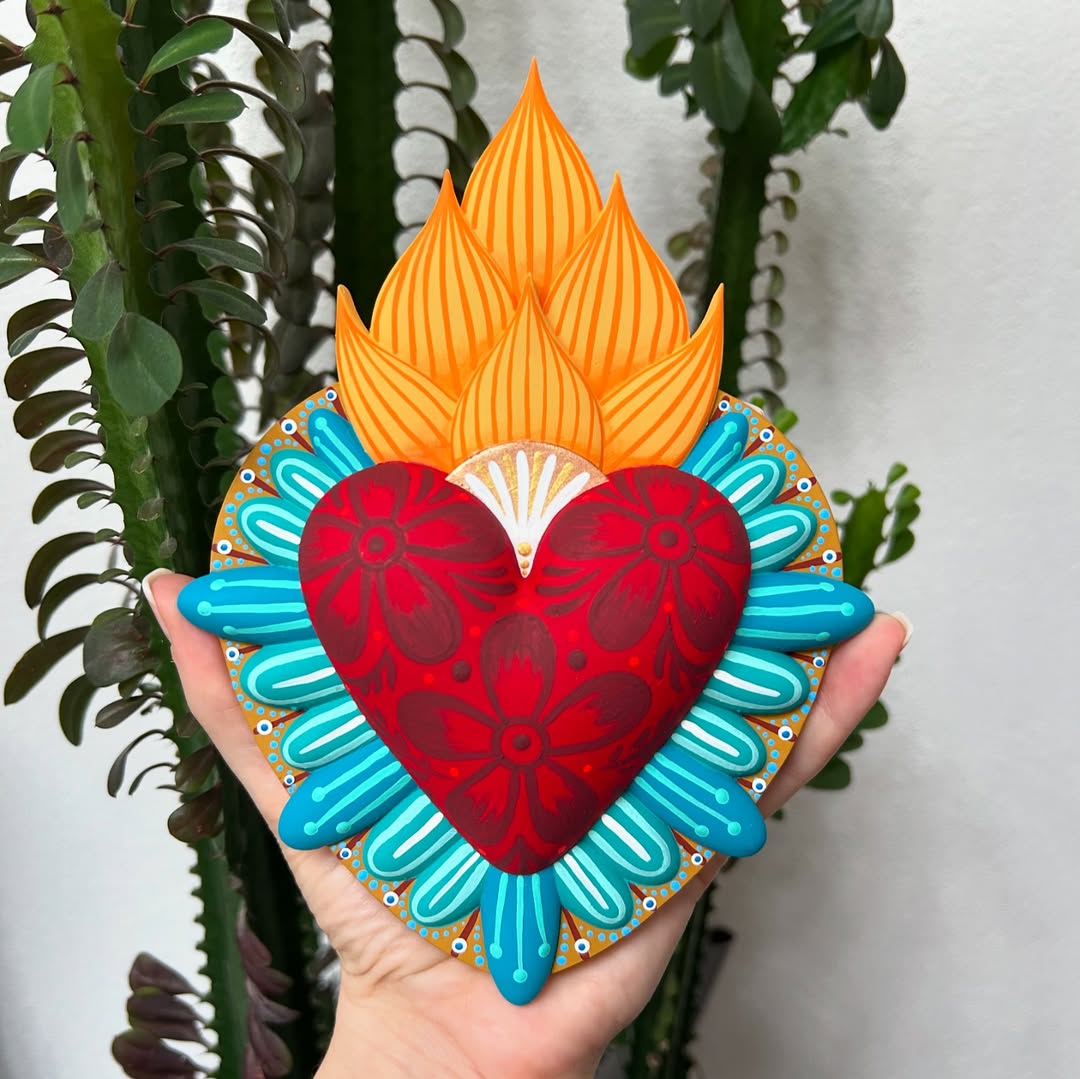 Hand-painted Mexican fire heart folk art sculpture with floral red heart, vibrant orange flames, and turquoise border, symbolizing love, passion, and spiritual devotion