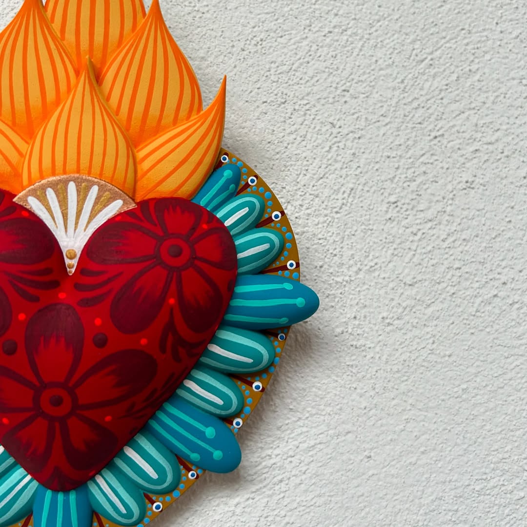 Hand-painted Mexican fire heart folk art sculpture with floral red heart, vibrant orange flames, and turquoise border, symbolizing love, passion, and spiritual devotion