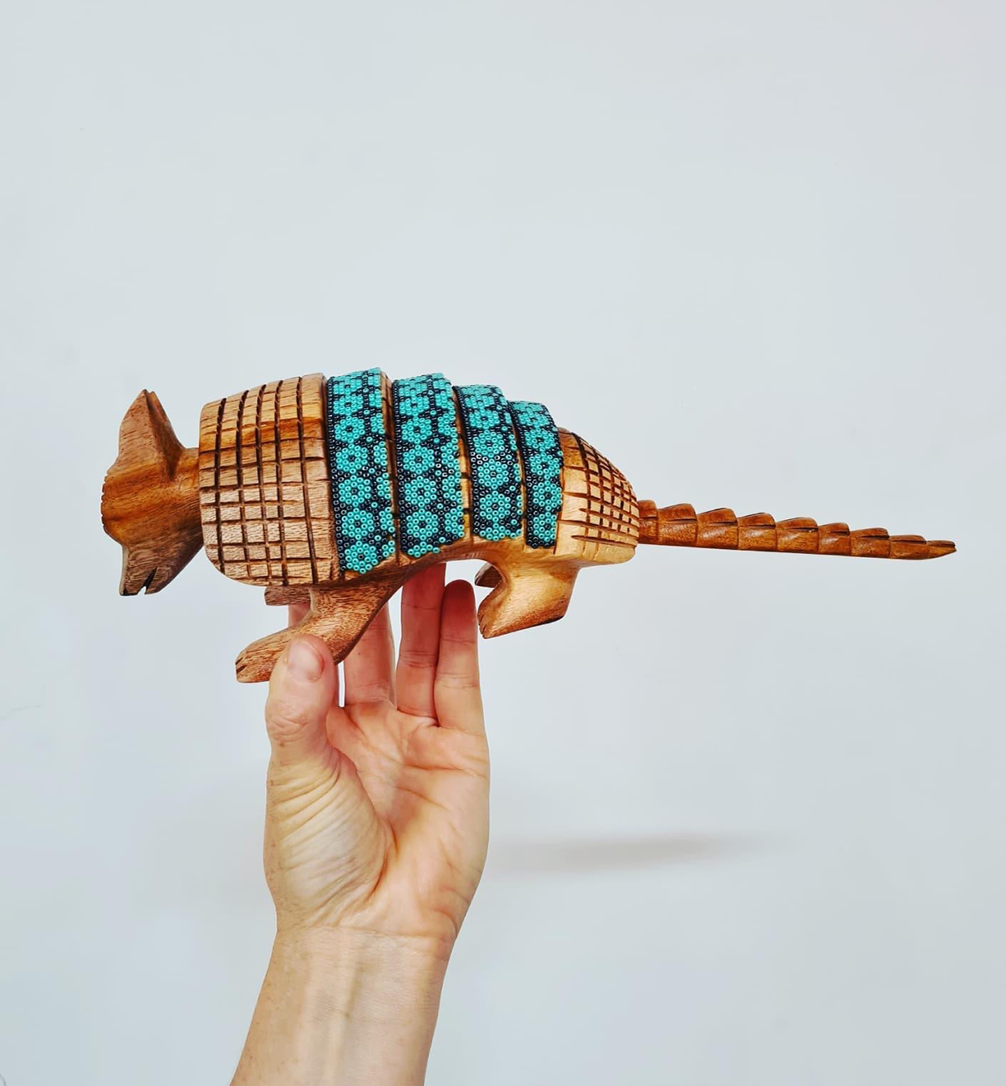 wooden armadillo figurine decorated with beads in the style of huichol art