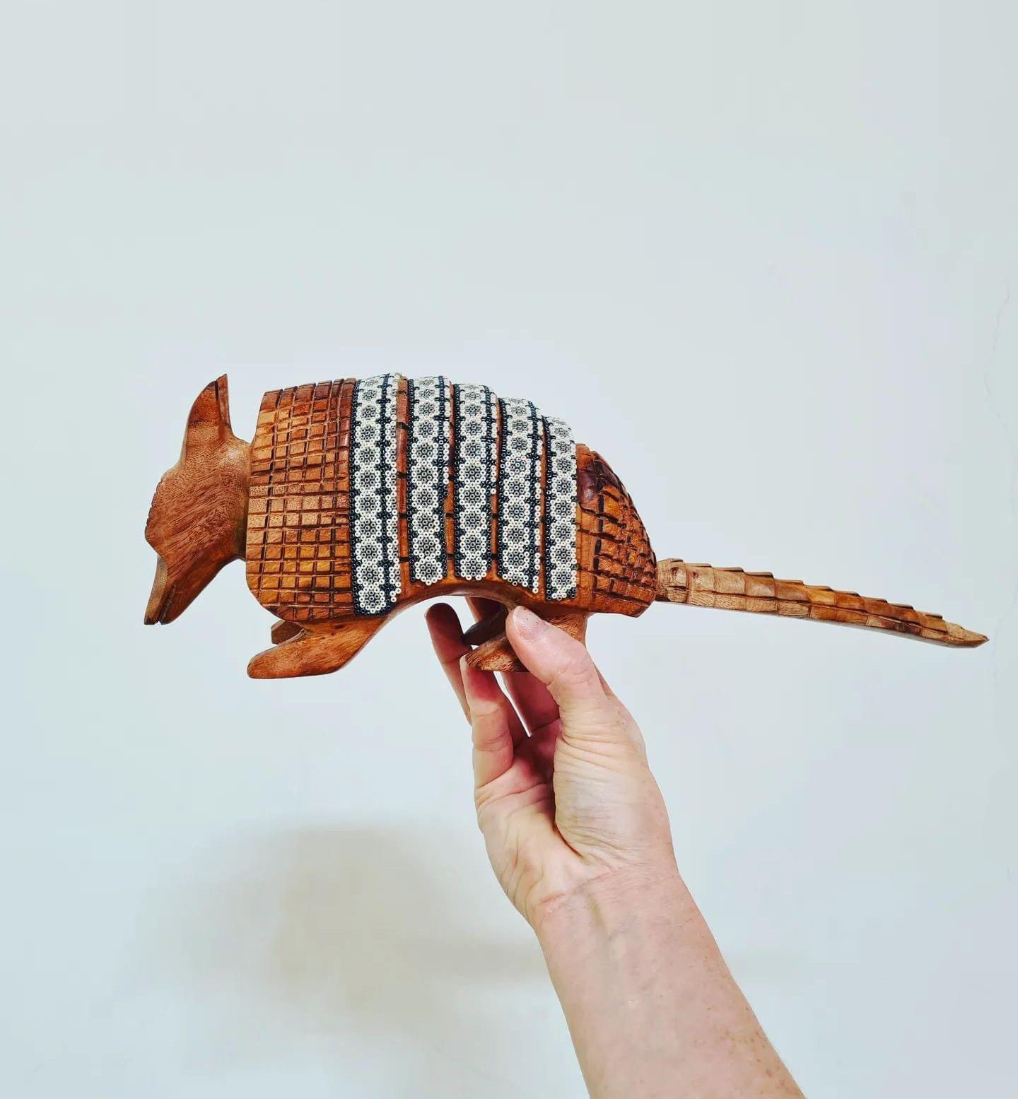 wooden armadillo figurine decorated with beads