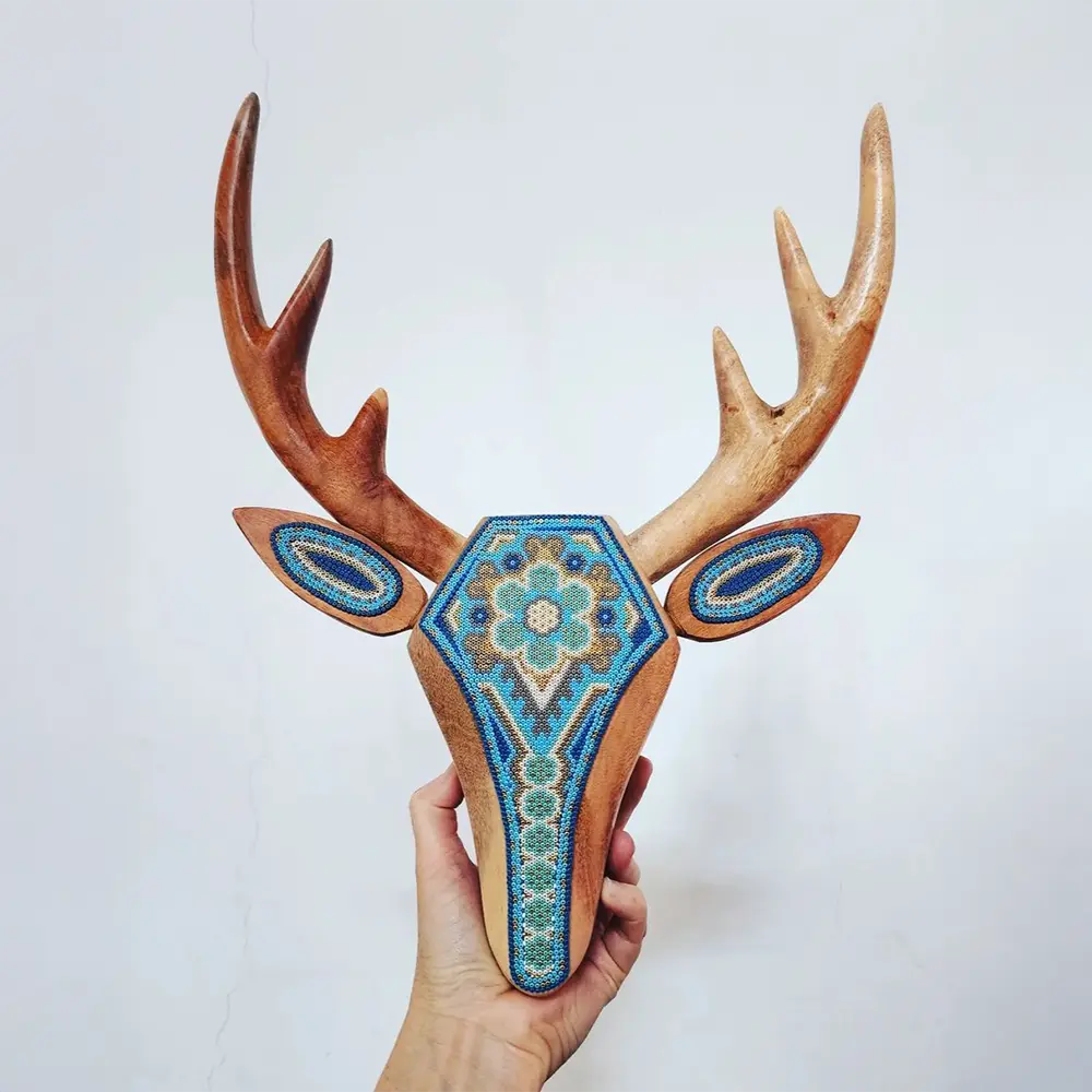 wooden deer sculpture dcorated with beads in the style of huichol art, mexican crafts