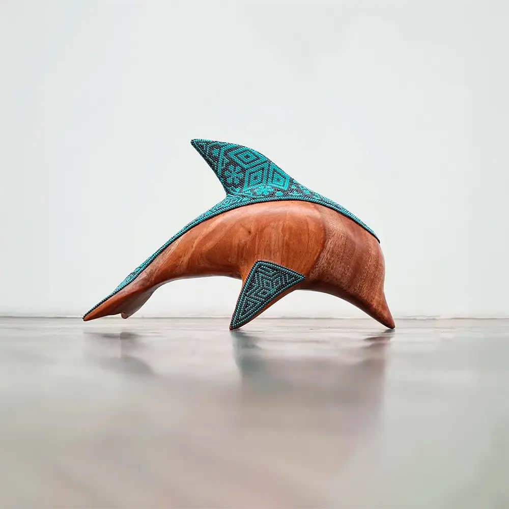 wooden dolphin sculpture decorated with beads in the huichol style, mexican crafts